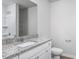Bathroom featuring a granite vanity top, bright lighting, white cabinets, and modern fixtures at 11320 International Dr, Middlesex, NC 27557