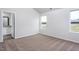 Bedroom with carpet floors, two windows overlooking wooded area, and an attached bathroom at 11320 International Dr, Middlesex, NC 27557