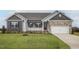 Charming single-story home featuring stone accents, covered porch, lush lawn, and an attached two-car garage at 11340 International Dr, Middlesex, NC 27557