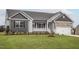 Charming single-story home with stone accents, covered porch, manicured lawn, and attached garage at 11340 International Dr, Middlesex, NC 27557