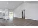 Spacious open floor plan with wood-look flooring connecting living area, kitchen, and dining space at 11340 International Dr, Middlesex, NC 27557
