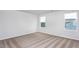 Bright bedroom featuring neutral carpet, two windows, and white walls at 11360 International Dr, Middlesex, NC 27557