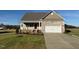 A single-story home with stone accents, a two-car garage, and a welcoming front porch, perfect for a new Gathering at 11360 International Dr, Middlesex, NC 27557