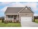 Charming home featuring a stone-accented facade, a welcoming porch, and an attached two-car garage at 11360 International Dr, Middlesex, NC 27557
