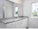 Bright bathroom featuring a granite countertop vanity and large mirror at 11376 International Dr, Middlesex, NC 27557
