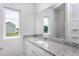Bright bathroom with granite countertop, large mirror, and window offering natural light at 11376 International Dr, Middlesex, NC 27557