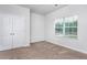 Carpeted bedroom with a window and a double door closet at 11376 International Dr, Middlesex, NC 27557