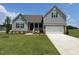 Charming two-story home with gray siding, stone accents, and well-manicured front lawn at 11376 International Dr, Middlesex, NC 27557