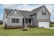 Charming two-story home with gray siding, brick accents, and a manicured lawn at 11376 International Dr, Middlesex, NC 27557