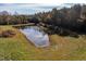 Aerial view of a pond surrounded by green space and woods at 206 Pike Memory Ln, Staley, NC 27355