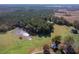 Panoramic aerial perspective of a home near a pond, showcasing its secluded setting amidst a dense forest and open land at 206 Pike Memory Ln, Staley, NC 27355