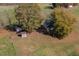 An aerial view of a traditional home, showcasing a large yard, outbuildings, and mature trees at 206 Pike Memory Ln, Staley, NC 27355