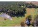 Breathtaking aerial shot of a home next to a tranquil pond surrounded by verdant trees and open fields at 206 Pike Memory Ln, Staley, NC 27355