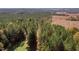 Expansive aerial view featuring lush trees, a field and more, highlighting land and privacy at 206 Pike Memory Ln, Staley, NC 27355