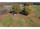An aerial view of a traditional home, showcasing a large yard, outbuildings, and mature trees at 206 Pike Memory Ln, Staley, NC 27355