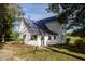 Rear exterior view of the farmhouse featuring a metal roof and a level, grassy backyard at 206 Pike Memory Ln, Staley, NC 27355