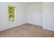 A bedroom featuring neutral carpet, white walls, and a window offering natural light at 206 Pike Memory Ln, Staley, NC 27355