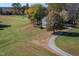 A view of the home from the driveway surrounded by a large yard and trees at 206 Pike Memory Ln, Staley, NC 27355