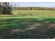 Expansive green field with a rustic wooden fence, blending nature with rural charm at 206 Pike Memory Ln, Staley, NC 27355
