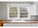 Close-up of a kitchen sink, cabinets, and bright natural light from the window at 206 Pike Memory Ln, Staley, NC 27355