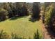 Lush green land surrounded by towering trees, offering privacy and a serene natural setting at 206 Pike Memory Ln, Staley, NC 27355