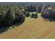 Scenic pasture bordered by mature trees offers a tranquil, bucolic setting at 206 Pike Memory Ln, Staley, NC 27355