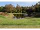 Scenic view of a tranquil pond surrounded by lush greenery and colorful autumn foliage at 206 Pike Memory Ln, Staley, NC 27355