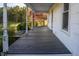 Inviting, covered porch featuring dark wood planks and views of the lush yard at 206 Pike Memory Ln, Staley, NC 27355
