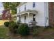 Exterior view showcasing a side porch with decorative columns and mature landscaping at 206 Pike Memory Ln, Staley, NC 27355
