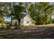 View of house with brick chimney, large yard, and mature trees in a rural setting at 206 Pike Memory Ln, Staley, NC 27355