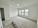 Well-lit bedroom featuring carpet, large windows, and a walk-in closet at 109 S Stone Mill W Trl # 238, Clayton, NC 27520