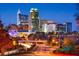 Downtown cityscape at night featuring the skyline, a bridge, and cars with light trails showcasing city life at 220 Augusta Pond Way # 126, Raleigh, NC 27603