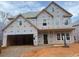 Exterior view of an unfinished two-story house with a large garage and multiple windows showcasing a promising architectural design at 220 Augusta Pond Way # 126, Raleigh, NC 27603