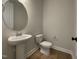 Half bathroom features a modern pedestal sink and toilet at 409 Marthas View Way, Wake Forest, NC 27587