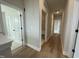 Hallway with light wood flooring and neutral walls leading to various rooms with white doors at 409 Marthas View Way, Wake Forest, NC 27587
