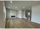 A spacious living room with light wood flooring, a modern fireplace, recessed lighting, and a staircase at 409 Marthas View Way, Wake Forest, NC 27587