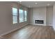 Bright living room with hardwood flooring, large windows, and an electric fireplace at 409 Marthas View Way, Wake Forest, NC 27587