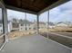 View of the outdoors from the screened-in porch with neutral-colored neighboring houses and an exposed wood ceiling at 409 Marthas View Way, Wake Forest, NC 27587