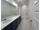 Bathroom featuring double sink vanity, marble counters, tub and marble floors at 6044 Scalybark Road, Durham, NC 27712