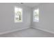 Bright bedroom with two windows showing the exterior and neutral colored carpet at 6044 Scalybark Road, Durham, NC 27712