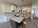 Elegant kitchen featuring an island, white cabinets, and stainless steel appliances, perfect for cooking at 6044 Scalybark Road, Durham, NC 27712