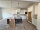 Modern kitchen with white cabinets, stainless appliances, island with counter seating and pendant lighting at 6044 Scalybark Road, Durham, NC 27712
