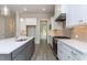 Modern kitchen featuring a large island, stainless steel appliances, and sleek gray and white cabinetry at 6044 Scalybark Road, Durham, NC 27712