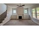 Inviting living room with a cozy fireplace and built-in shelving units, plus staircase to second floor at 6044 Scalybark Road, Durham, NC 27712