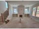 Bright living room with fireplace flanked by built-in shelving, staircase, and natural light at 6044 Scalybark Road, Durham, NC 27712