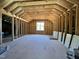 An unfinished attic featuring a window, wood framing, and room for storage at 6044 Scalybark Road, Durham, NC 27712
