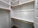 View of walk-in closet with custom shelving, rods and wood trim at 6044 Scalybark Road, Durham, NC 27712
