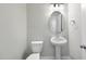 Contemporary half-bathroom featuring a pedestal sink, oval mirror, and a modern toilet at 77 Buckhorn Branch Park # 174, Clayton, NC 27520