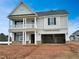 Two-story home featuring a garage, porch, and neutral siding against a clear blue sky at 77 Buckhorn Branch Park # 174, Clayton, NC 27520