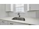 Close-up of a kitchen sink featuring white cabinets, quartz countertop, and stainless steel faucet at 77 Buckhorn Branch Park # 174, Clayton, NC 27520
